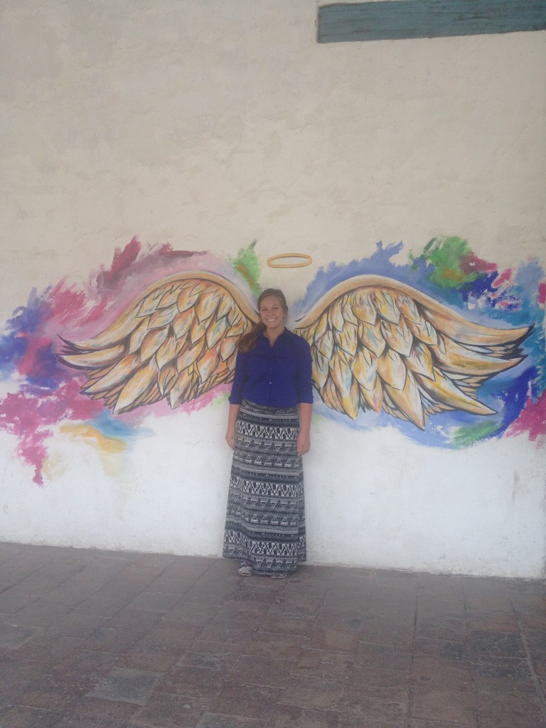 Emily poses with angel wings on one of the buildings in the city.