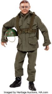 GI Joe doll from 1964 dressed in full body green fatigues, holding a helmet. He is of average/slim body size/shape