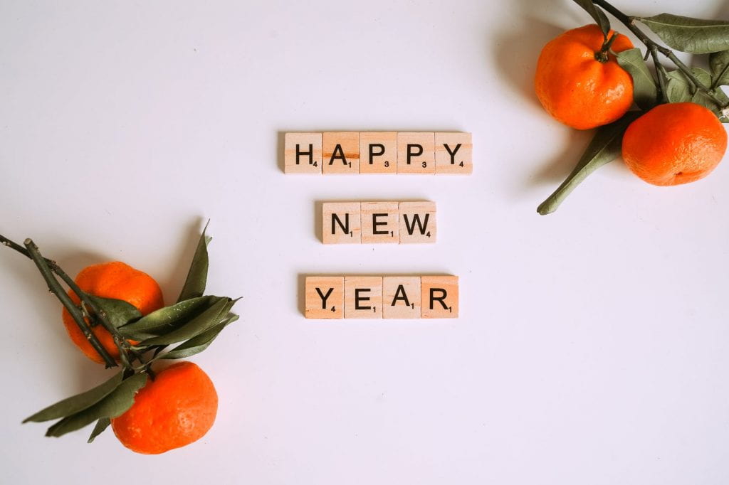 Tiles that read Happy New Year with mandarin oranges on white background