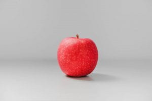 Red apple in front of a gray background