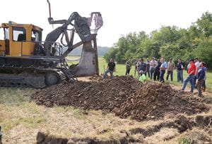 Visitors to the drainage field day at Ohio State Lima observe machinery in the field.