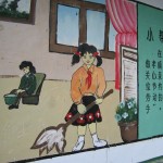 Propaganda mural of obedient children working and slogans written to their right