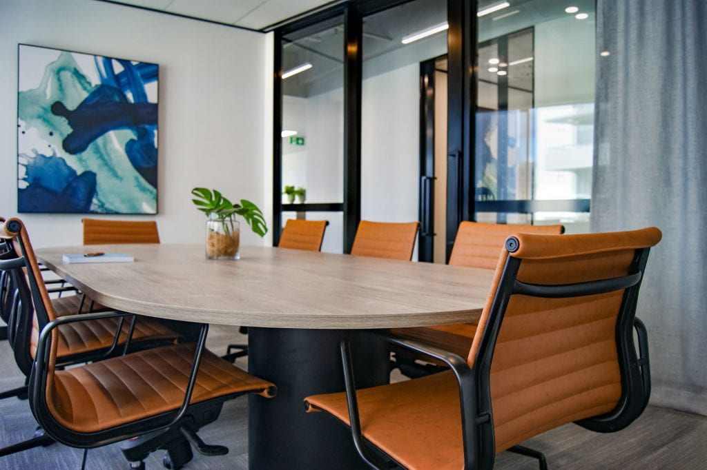 Tan office chairs around circular meeting table