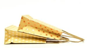 Yellow paper shopping bags with polka dots and stars.