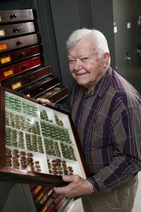 Chuck Triplehorn holding a drawer of scarabs that is still exactly like Joe Knull left it.