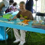 Educator at a craft activity table outdoors