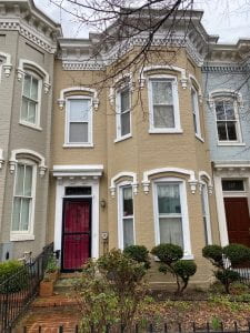 Traditional DC Row House with tan paint and red door.