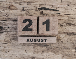cube calendar for august on wooden background with copy space