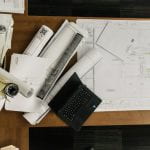 House plans, laptop, rolled drawings