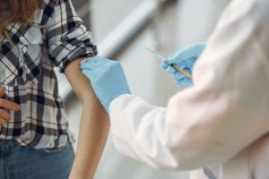 Medical professional administering vaccine to someone